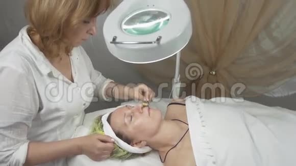 美容师在美容院做成年女性的电流治疗视频的预览图