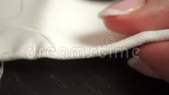 美丽女人手缝白布和白线的宏观视频视频的预览图