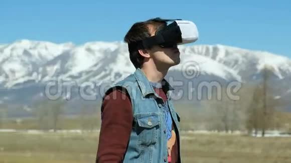 人在360伏头盔在湖岸走开公园里的年轻人在秋天的风景中观看360度的视频视频的预览图