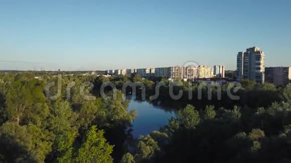 在黎明时分飞过城市的树木和湖泊空中录像视频的预览图