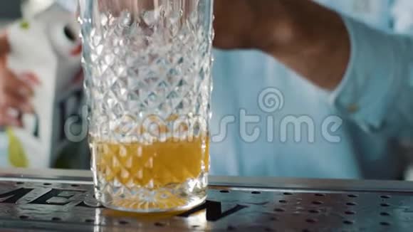 酒保将饮料倒入玻璃杯中的特写镜头视频的预览图