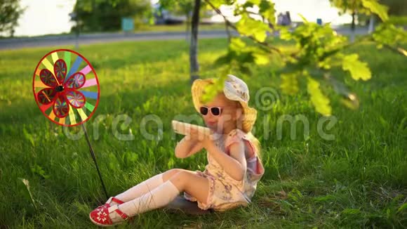 日落时分快乐的孩子在一个公共公园橡树下玩草视频的预览图