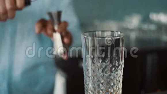 酒保将饮料倒入玻璃杯中的特写镜头视频的预览图