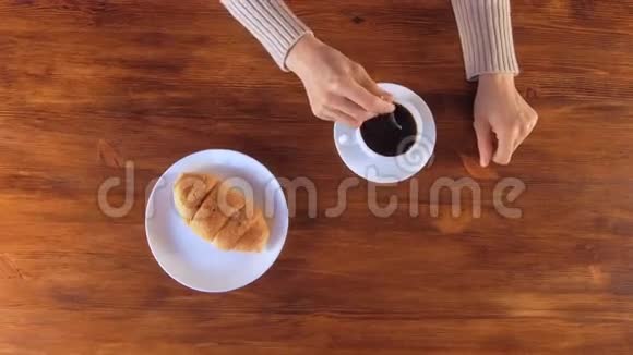 女士早餐喝黑咖啡加牛角面包视频的预览图