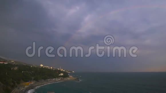 在一片阴云密布的天空的背景下彩虹在海面上视频的预览图