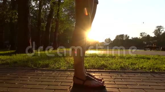 夏季日落公园里穿凉鞋的女孩慢镜头视频的预览图