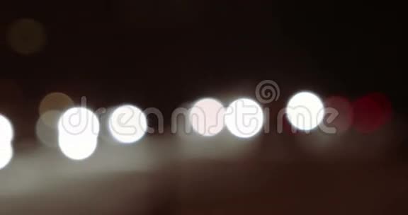 在冬天的夜晚汽车在道路降雪中散焦视频的预览图
