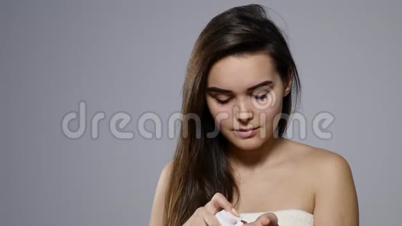 年轻漂亮的女人脸上涂着奶油灰蒙蒙的视频的预览图