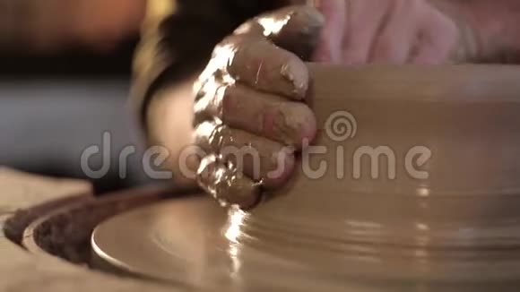传统的陶器制作用陶工他的手用粘土在旋转上塑造一个碗视频的预览图