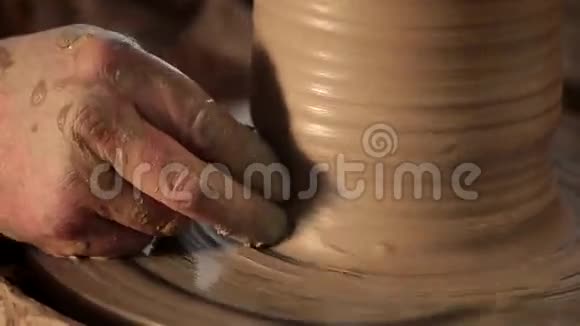 传统的陶器制作用陶工他的手用粘土在旋转上塑造一个碗视频的预览图