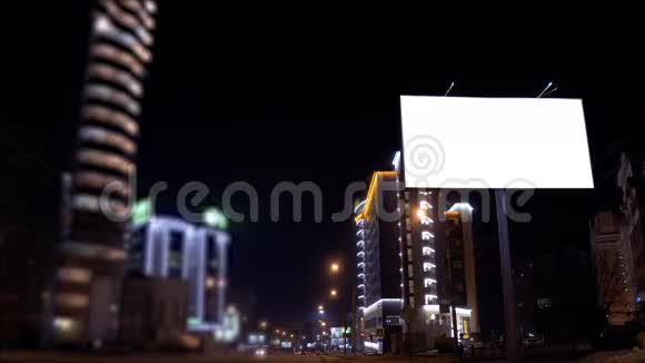 时光流逝的城市场景街道一侧有一块照明的空广告牌汽车在行驶视频的预览图