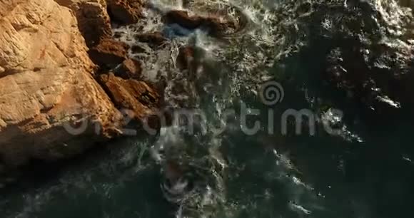 大石头伸出水面冲刷地中海的石质海岸视频的预览图