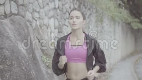 漂亮的黑发健身女人在户外跑步视频的预览图