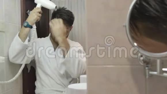 穿浴袍的年轻人在浴室里晒头发视频的预览图