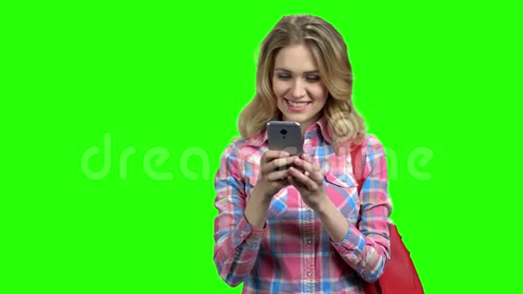 漂亮的女人在绿色屏幕上使用智能手机视频的预览图