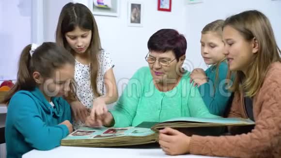 祖母向四个孙女展示旧相册视频的预览图
