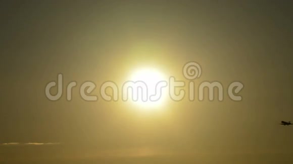 在日落时分飞机经过并降落在太阳前视频的预览图