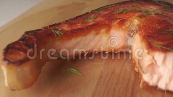 拿一块新鲜煮熟的鲑鱼牛排和叉子视频的预览图