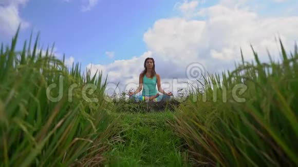 一位年轻女子用巴厘岛的方式为穆拉哈拉查克拉做冥想的慢动作稳定镜头视频的预览图