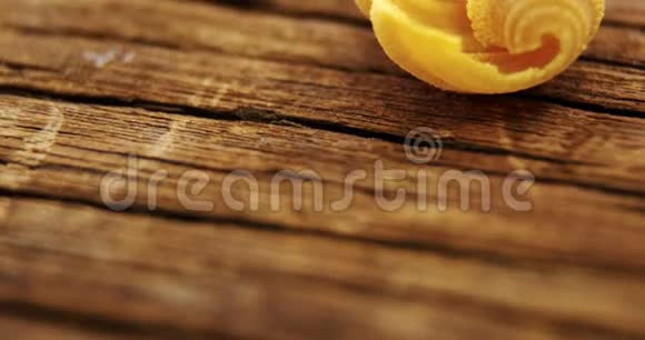 木制桌子上的黄色海螺意大利面视频的预览图