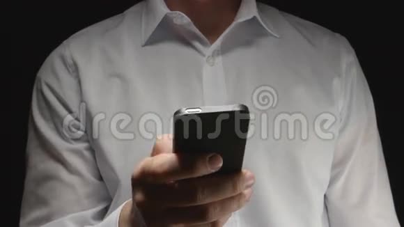 穿白色衬衫的人手拿着智能手机摸着它视频的预览图