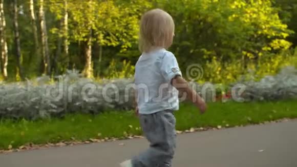 小男孩在公园的路上散步视频的预览图