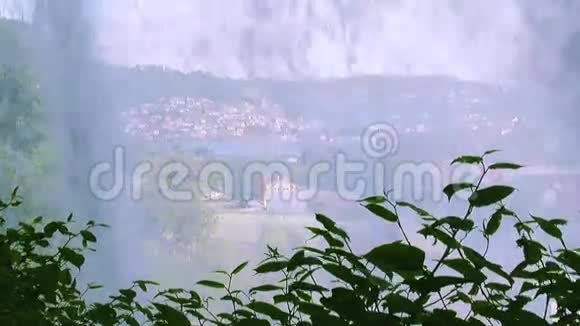 镜头前的瀑布飞溅丘陵乡村的城市景观小房子夏日晴天视频的预览图