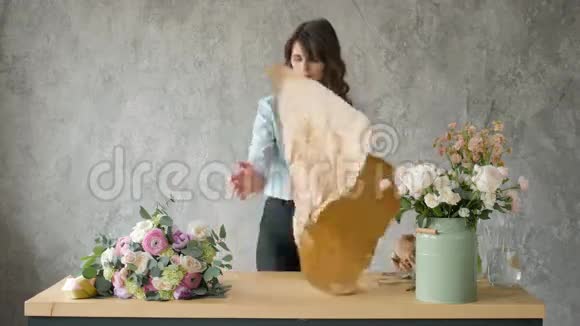 工作中的花商年轻漂亮的金发女人手里拿着时尚的现代花束里面有佩恩和玫瑰视频的预览图