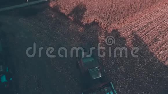 农业机械收割机和收割机在小麦或玉米地工作时的空中视野视频的预览图