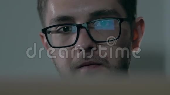 戴黑边眼镜的人在办公室用电脑镜头有屏幕反射的商人视频的预览图