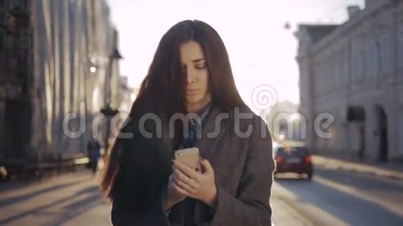 快乐的女人在奥图姆的街上散步和使用智能手机户外移动智能手机的学生女孩视频的预览图