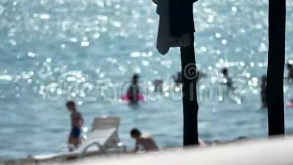 海边的人们在海滩上模糊的背景夏日的海洋视频的预览图