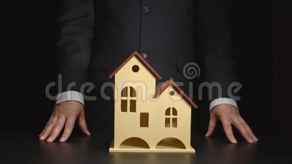 商人在桌子上展示房子模型视频的预览图
