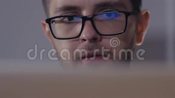 戴黑边眼镜的人在办公室用电脑镜头有屏幕反射的商人视频的预览图