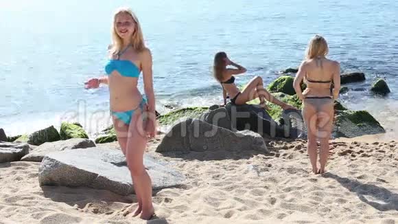 穿着泳装站在沙滩上的女人视频的预览图