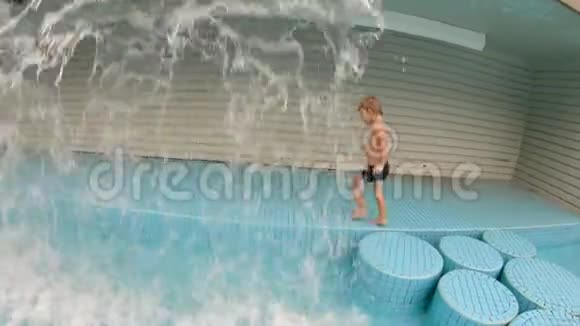 一个小男孩在公园的游泳池里玩的慢镜头视频的预览图