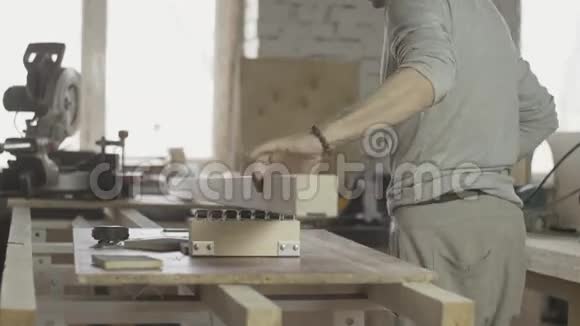 木工将长木工板的边缘放在圆锯下家具视频的预览图