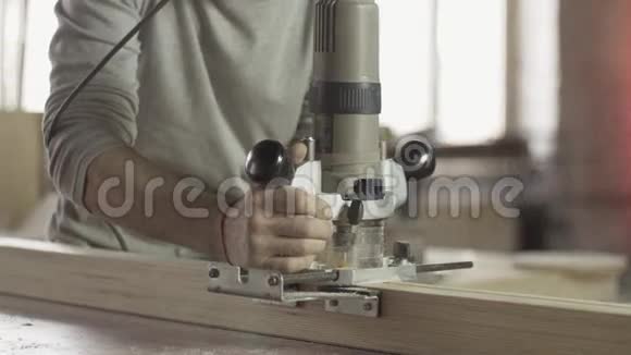 专业锁匠切割木板在支柱线上的插入路由器视频的预览图