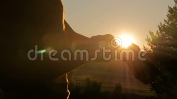 日落时分在森林里用智能手表的女人视频的预览图