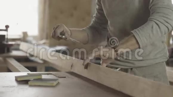 成人锁匠用专用尺测量木板家具木工视频的预览图