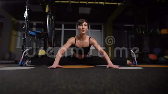 健身运动训练健身房和生活方式概念在健身房里用耳机伸展年轻女性视频的预览图