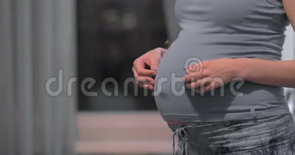 孕妇抚摸并拥抱腹部视频的预览图