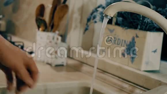 女人正在厨房里用肥皂洗碗带有侧面摄像机运动的特写镜头视频的预览图
