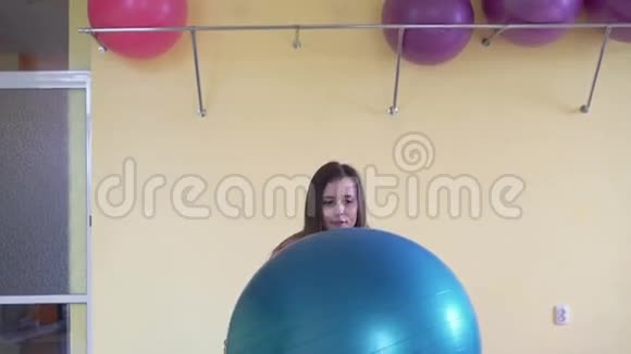 穿着运动服的女人用健身球做健身运动视频的预览图
