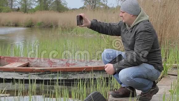 Hiker在湖边拍摄平板电脑视频的预览图