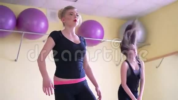 运动女孩在健身房同步做敏捷练习4k视频的预览图