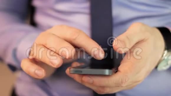 特写男人用手机触屏视频的预览图