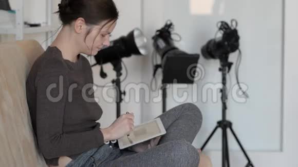 漂亮的女孩与平板电脑在一个轻沙发疲劳僵硬的脖子视频的预览图