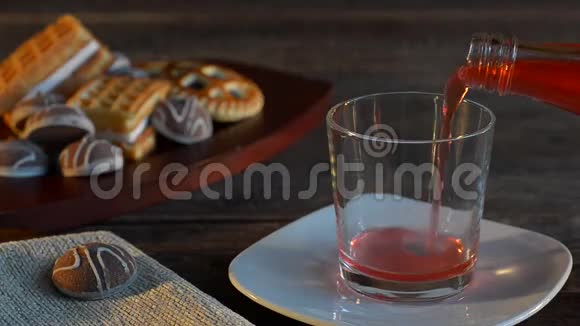 果汁倒入玻璃杯中饼干放在黑暗的背景上人工照明和选择性聚焦视频的预览图