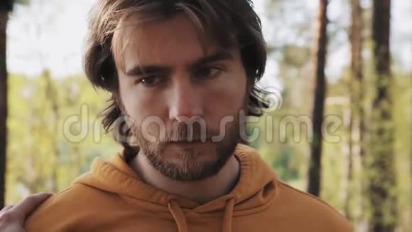 一个长头发的愤怒男人在树林里和朋友吵架视频的预览图